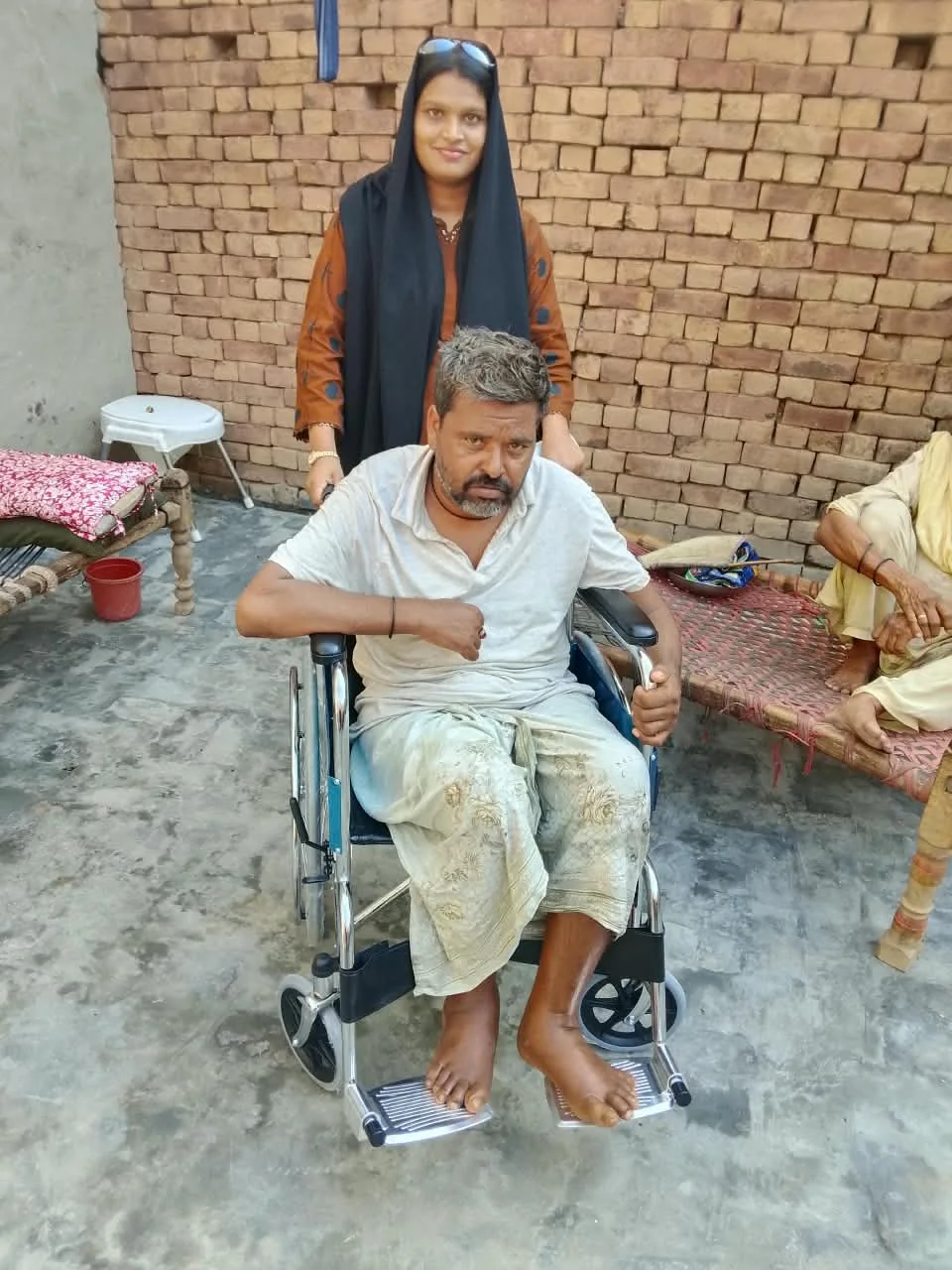 A community member in a wheelchair with visitors nearby