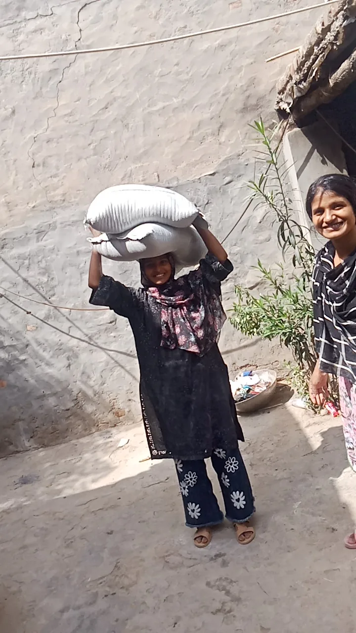A community member carrying sacks of supplies