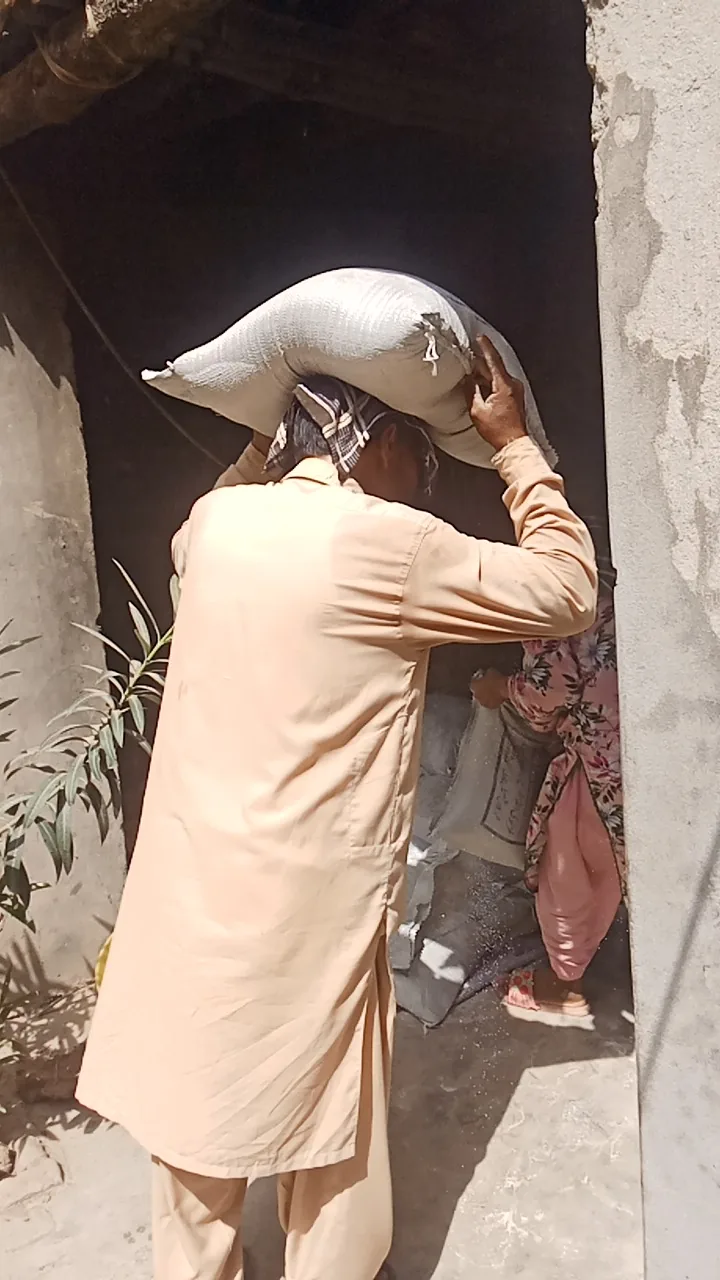 A community member carrying a sack of supplies into a home