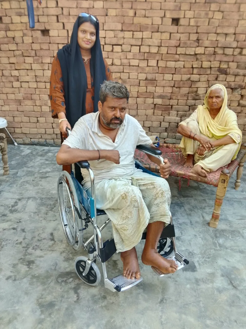 A community member seated in a wheelchair during a home visit